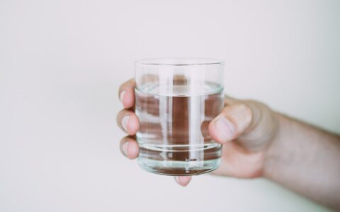 Person holding a glass of water